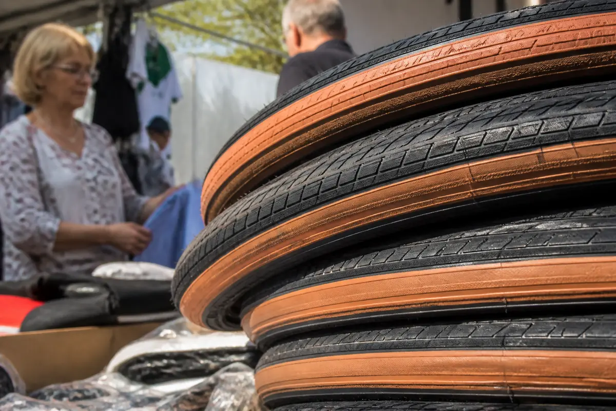 Piles de pneus Veloflex orange devant un stand de marché en extérieur